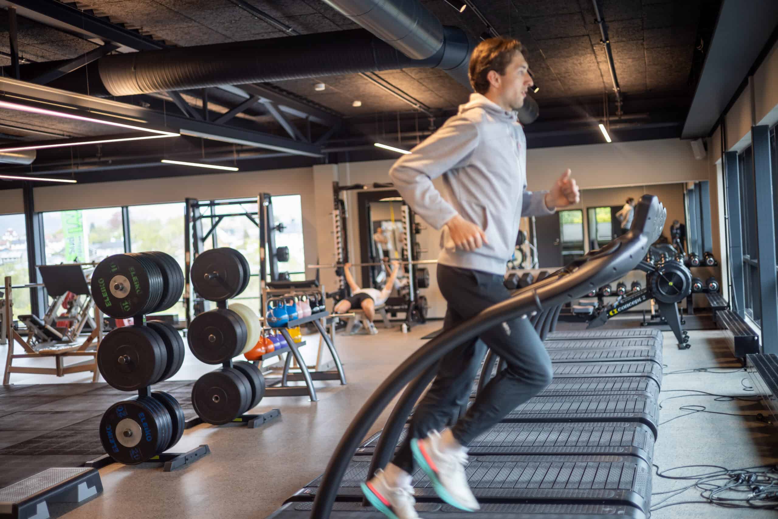 Løper i fart på mølla i treningssalen